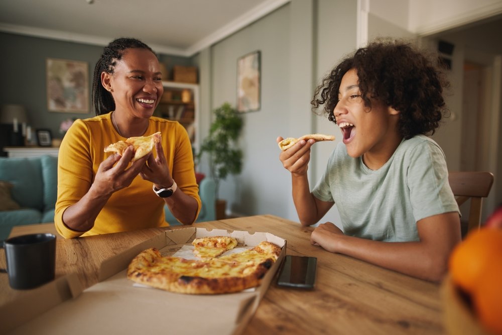 Mother,And,Teenage,Son,Having,Pizza,At,Home